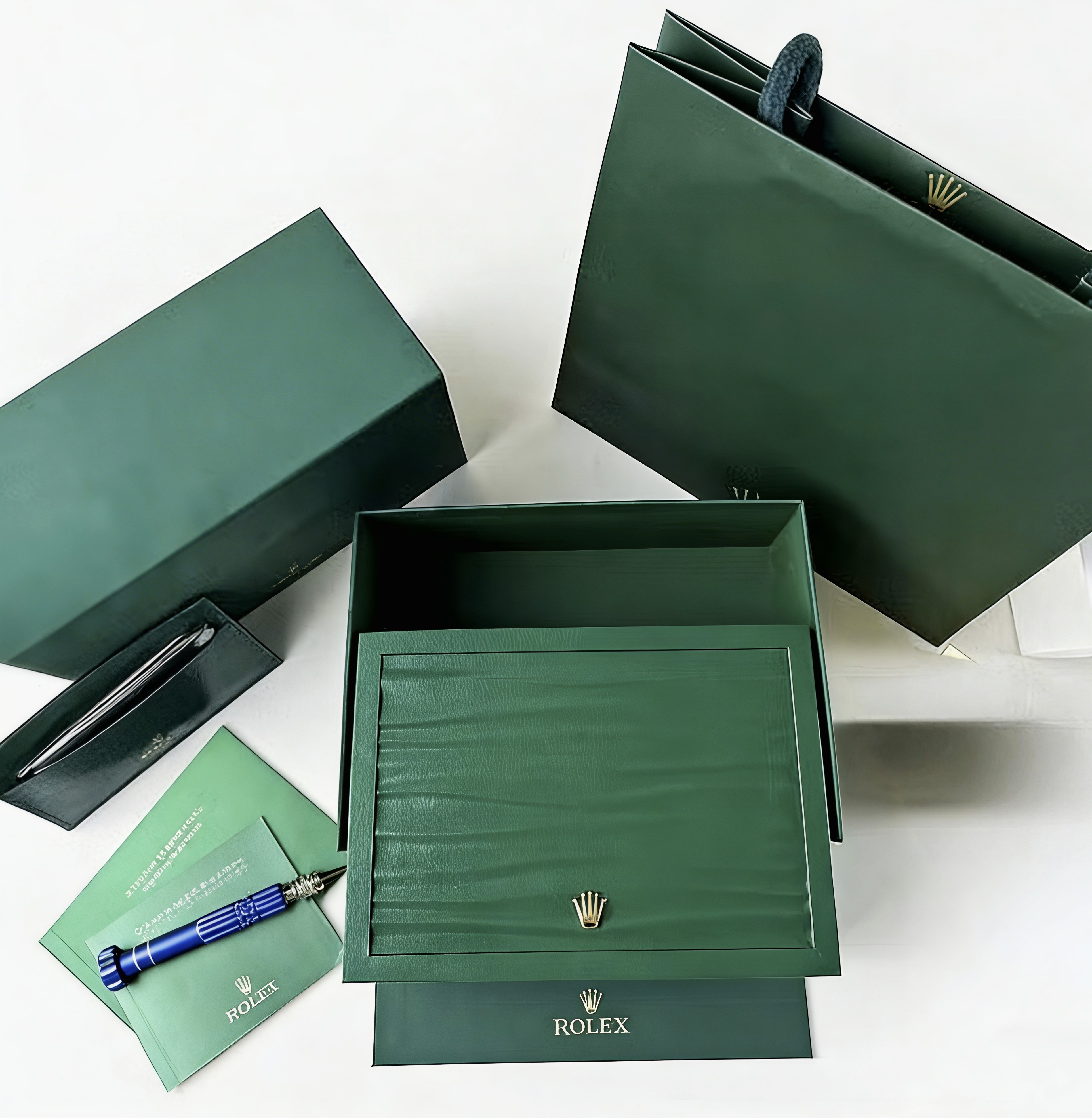 Open green watch box with booklet and card accessories