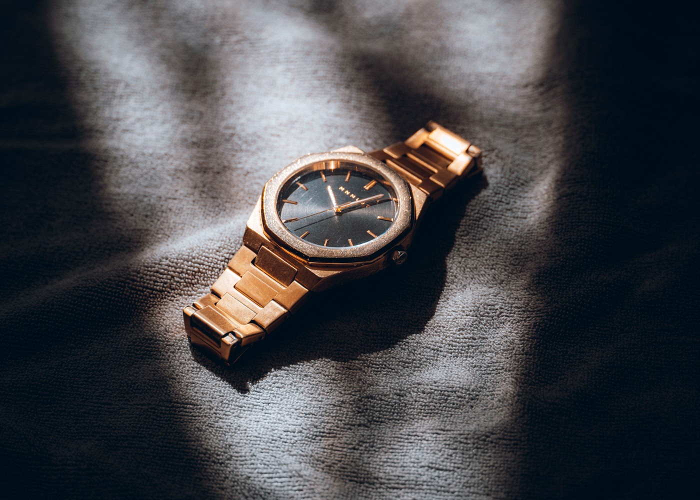 Gold-tone wristwatch on dark leather showing warm metal finish