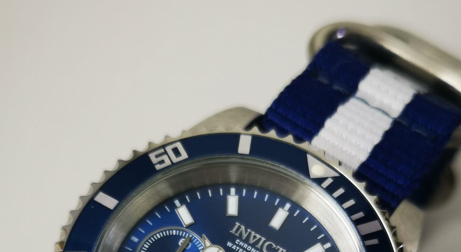 Close view of a watch dial, applied markers, and polished case edge
